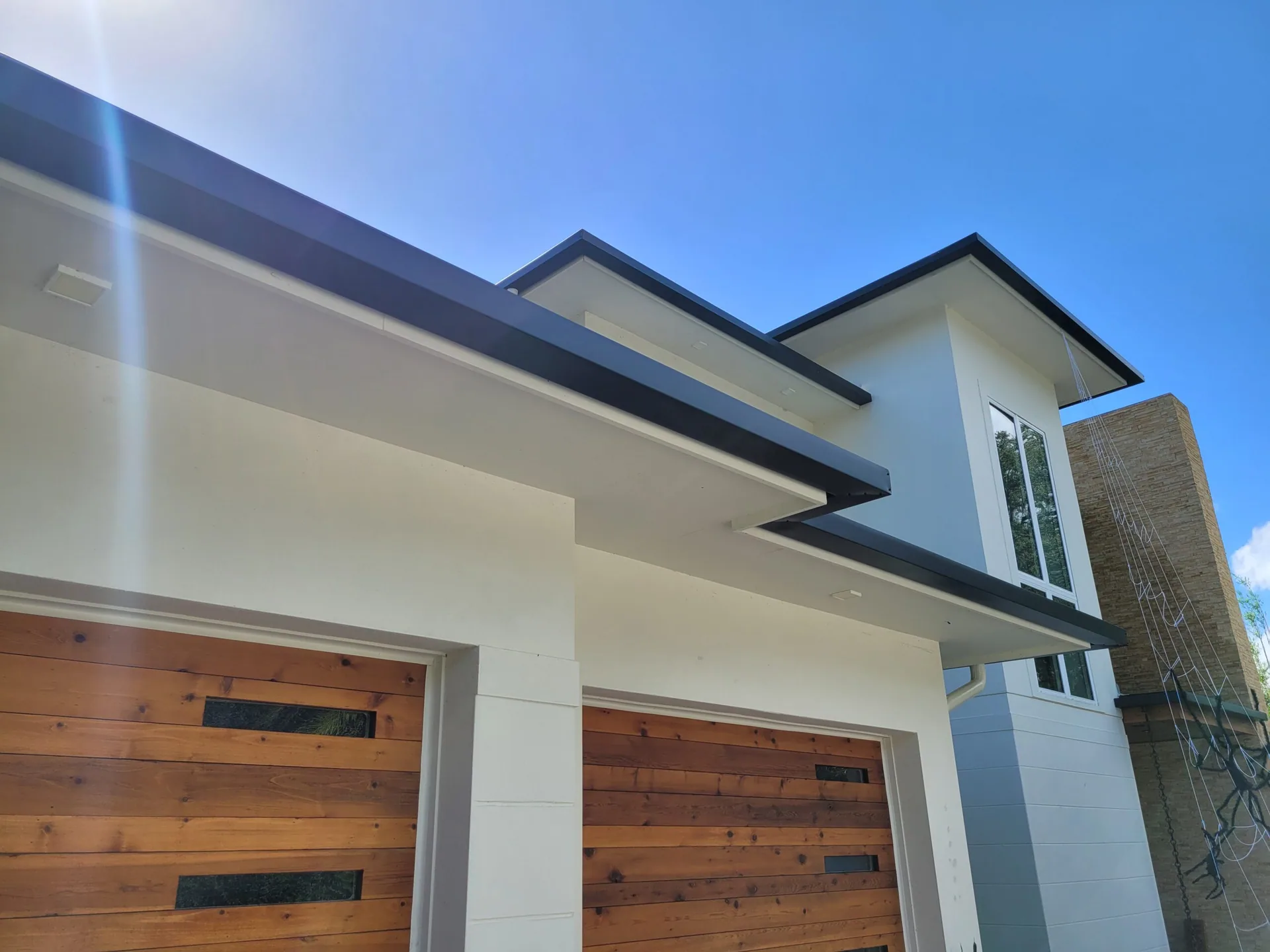 Low angle black fascia cedar garage doors, Heathrow